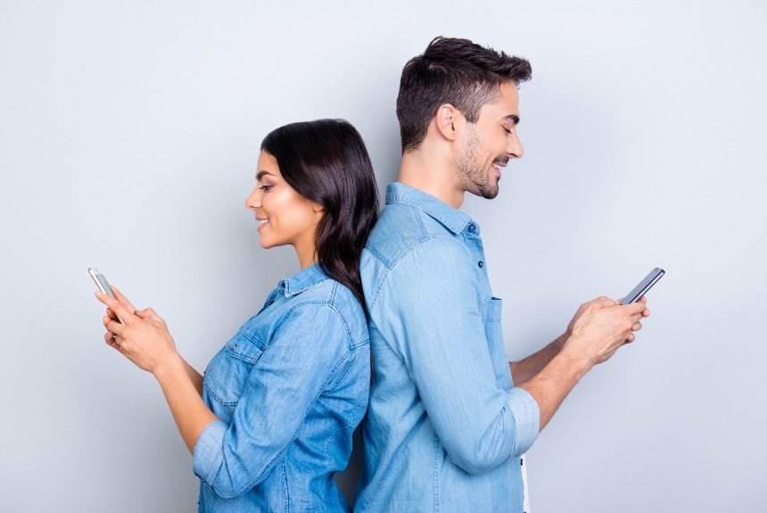 Мужчина и женщина смотрят в телефоны 